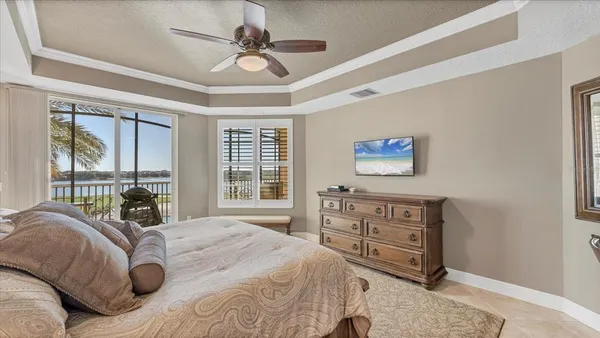 a bedroom with a bed a window and a flat screen television