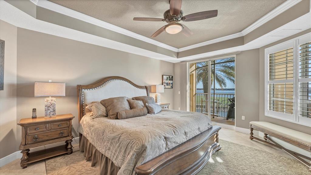 6414 Water Crest Way, Unit 302 Lakewood Ranch, FL 34202 - Photo 29 of 74 a bedroom with a large bed and a ceiling fan