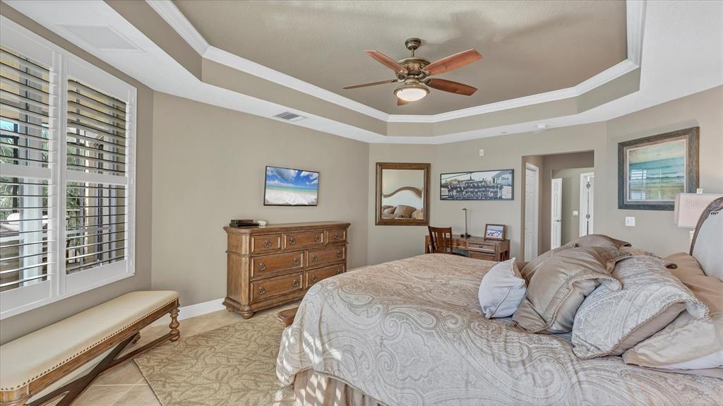 6414 Water Crest Way, Unit 302 Lakewood Ranch, FL 34202 - Photo 30 of 74 a bedroom with a bed and a chandelier