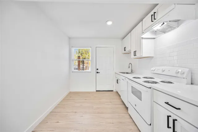 a kitchen with a stove top oven sink and cabinets
