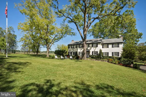 a view of a house with a big yard and large trees