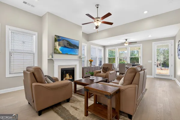 a living room with furniture a fireplace and a ceiling fan