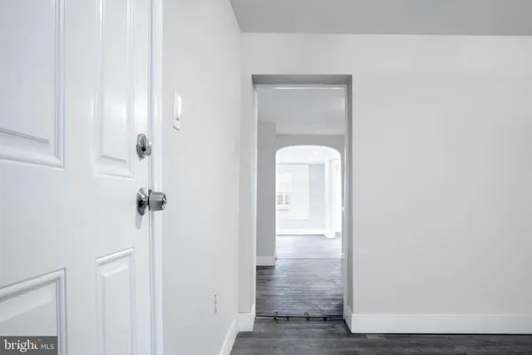 a view of an empty room with wooden floor and stairs