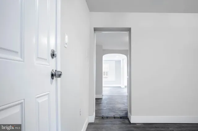 a view of an empty room with wooden floor and stairs