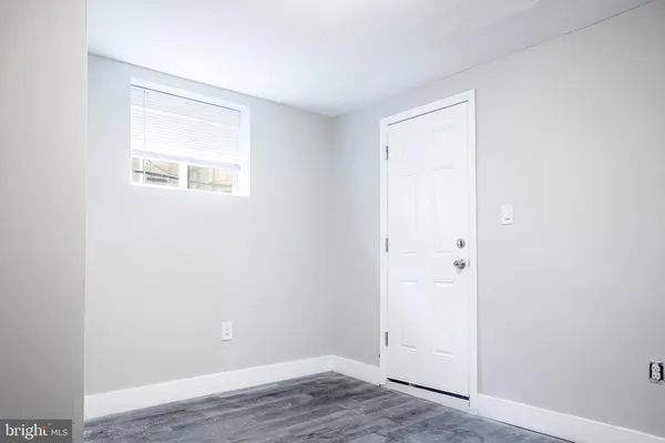 an empty room with wooden floor and a window