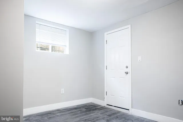 an empty room with wooden floor and a window