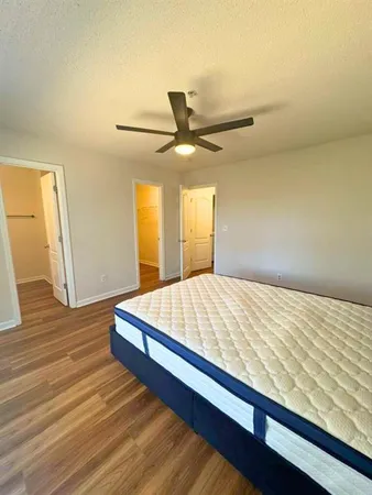 a bedroom with a bed and wooden floor