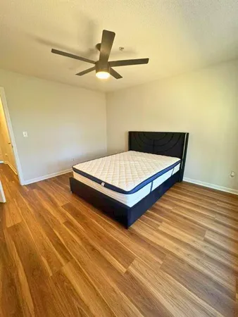 a bedroom with a bed and a ceiling fan