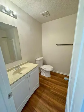 a bathroom with a granite countertop sink toilet and a mirror