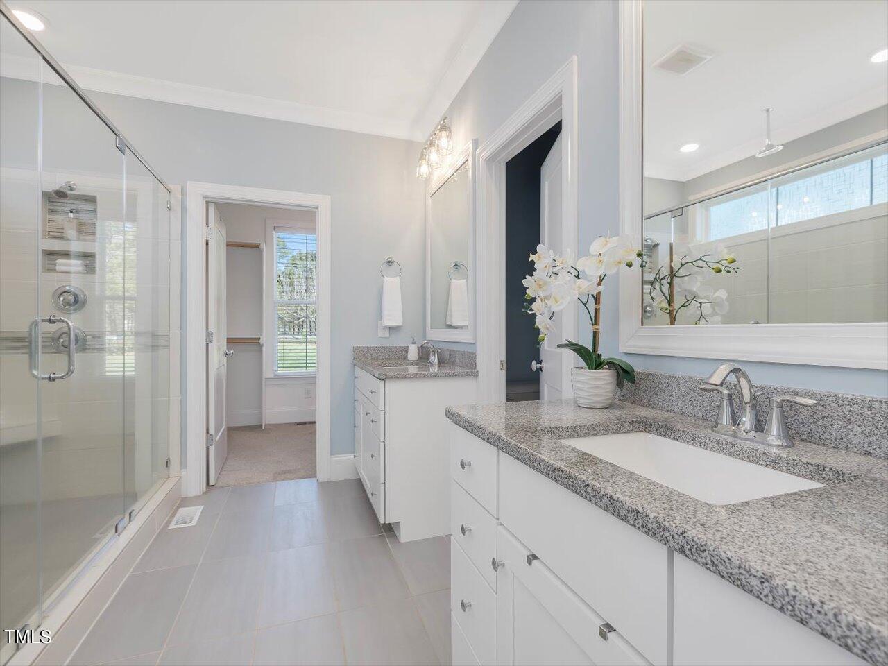 9117 Penny Road Raleigh, NC 27606 - Photo 22 of 72 a bathroom with a granite countertop sink mirror and a shower