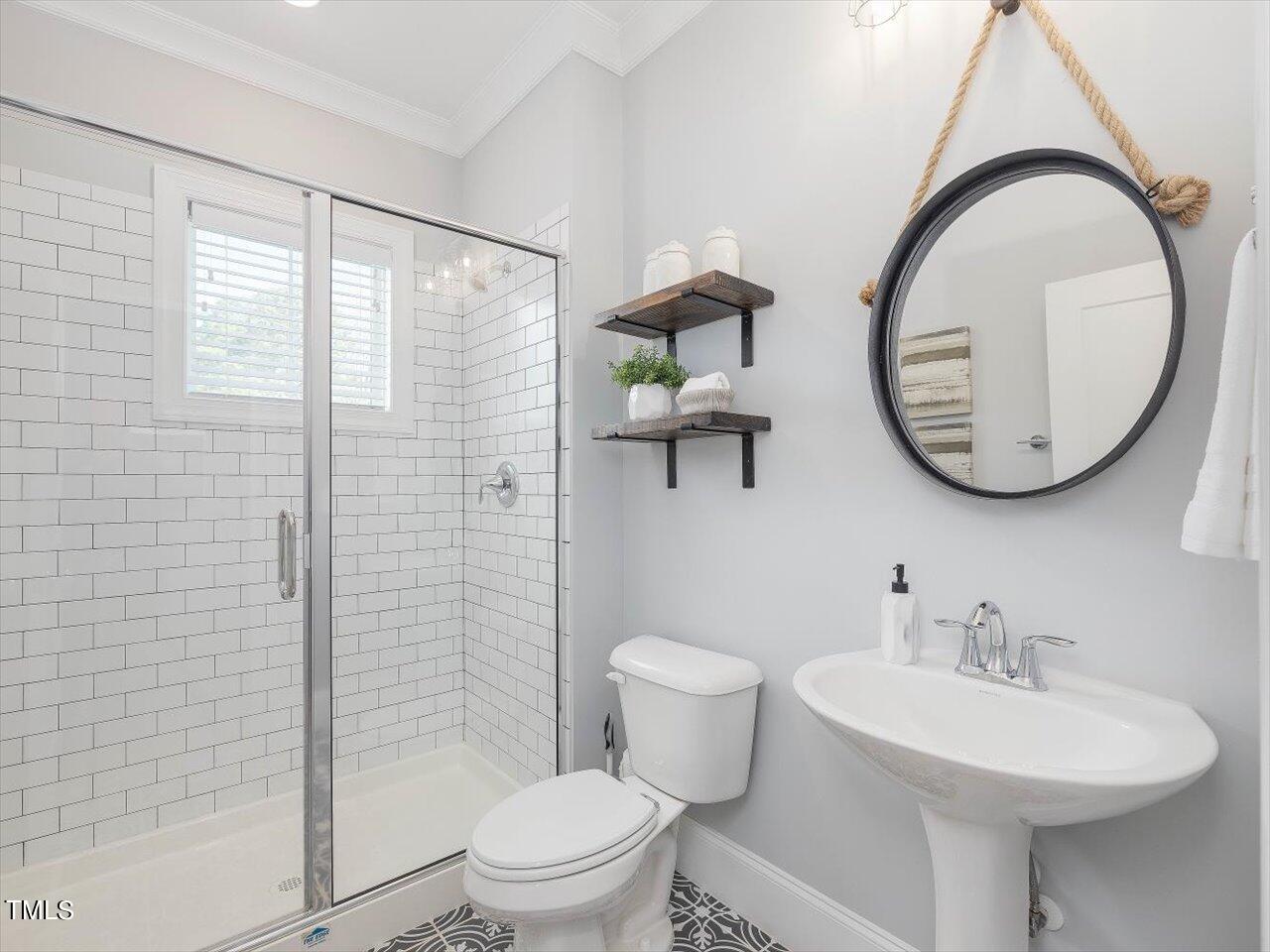 9117 Penny Road Raleigh, NC 27606 - Photo 27 of 72 a bathroom with a sink a mirror a toilet and a shower
