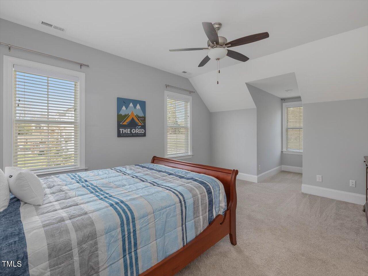 9117 Penny Road Raleigh, NC 27606 - Photo 33 of 72 a bedroom with a large bed chandelier and a window