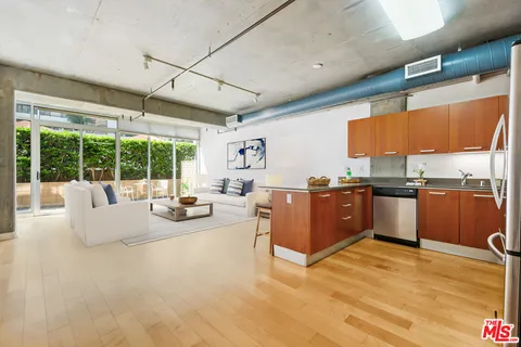 a view of kitchen with stainless steel appliances granite countertop a stove and cabinets