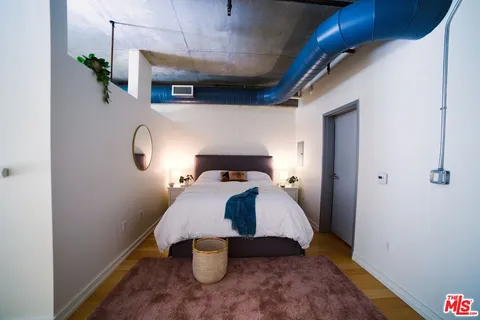 a bedroom with a bed and wooden floor