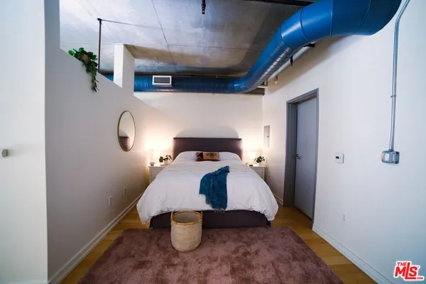 a bedroom with a bed and wooden floor