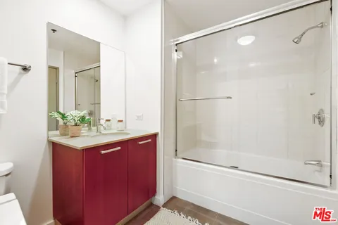 a bathroom with a shower sink vanity and mirror