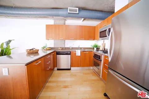 a kitchen with stainless steel appliances granite countertop a stove a sink and a refrigerator