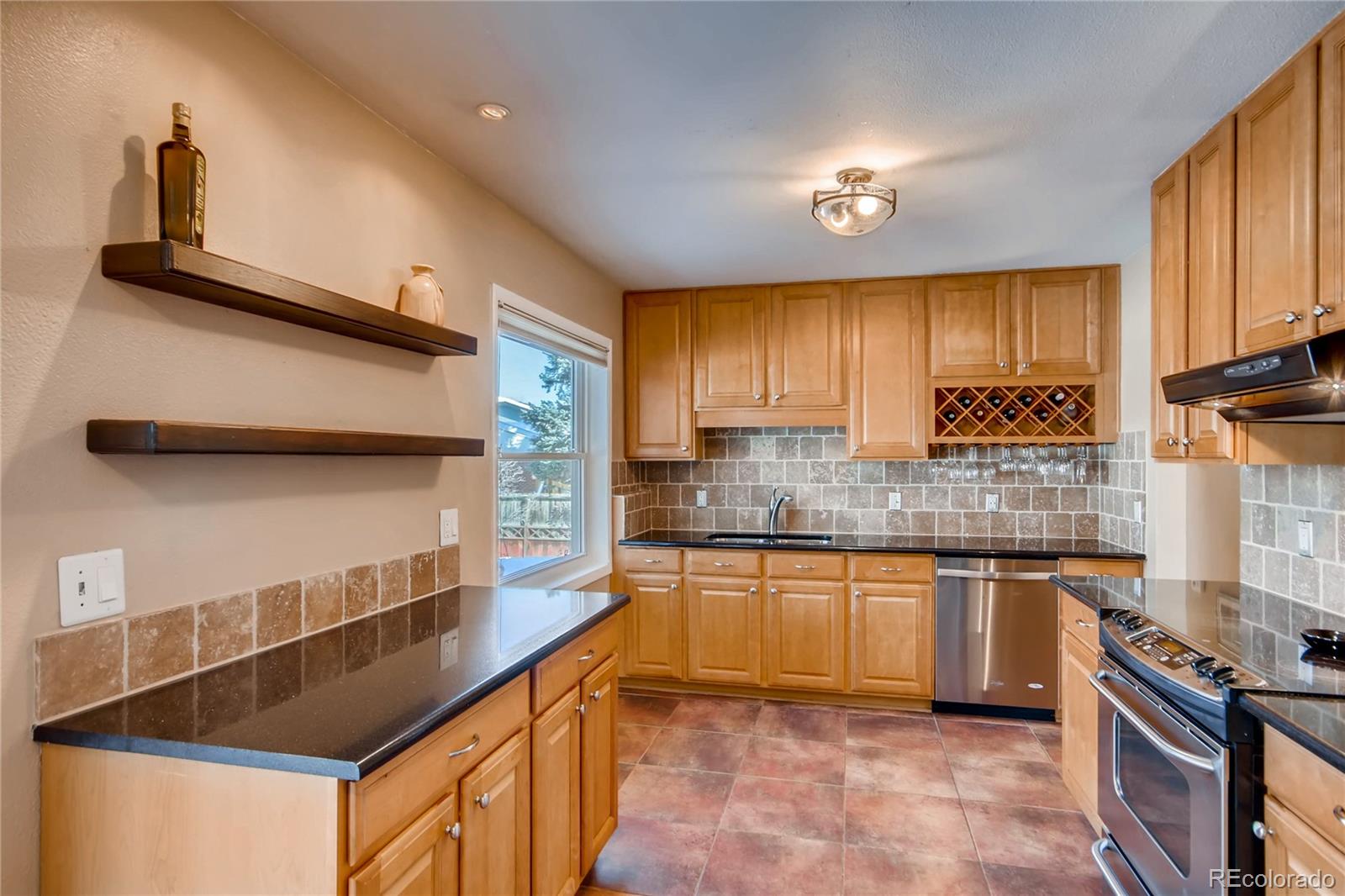 3315 West Pimlico Avenue Englewood, CO 80110 - Photo 6 of 35 a kitchen with granite countertop a sink stainless steel appliances wooden cabinets and a counter top space