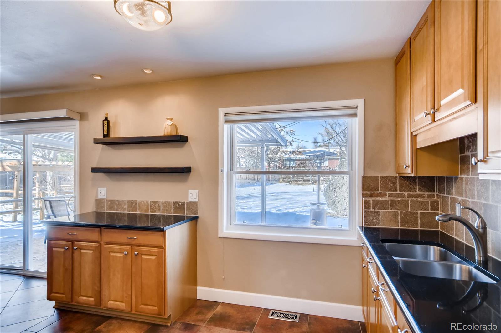 3315 West Pimlico Avenue Englewood, CO 80110 - Photo 7 of 35 a kitchen with granite countertop wooden cabinets a stove a sink and a refrigerator with wooden floor