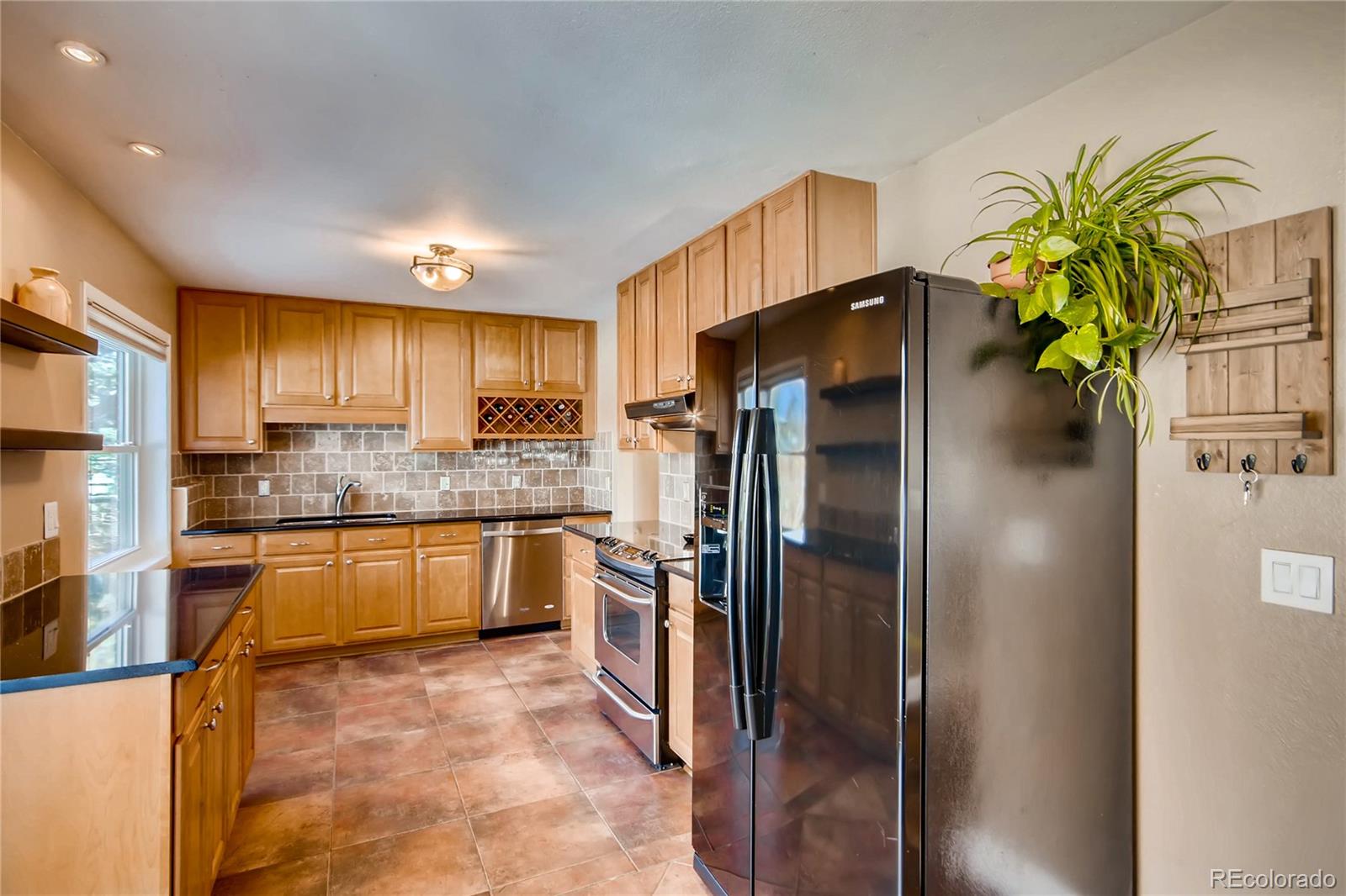 3315 West Pimlico Avenue Englewood, CO 80110 - Photo 8 of 35 a kitchen with stainless steel appliances a refrigerator a sink a stove and cabinets