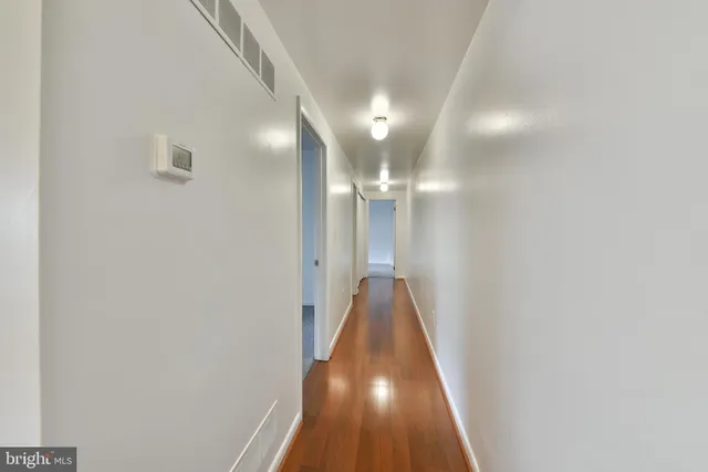 a view of a hallway with wooden floor