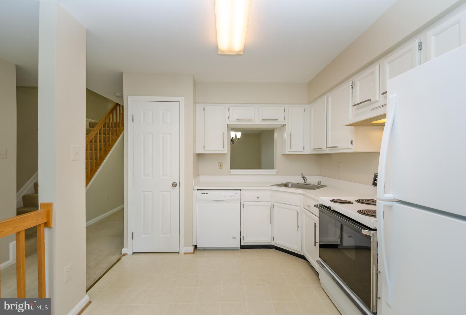 9502 Clocktower Lane Columbia, MD 21046 - Photo 2 of 12 a kitchen with granite countertop white cabinets and white appliances