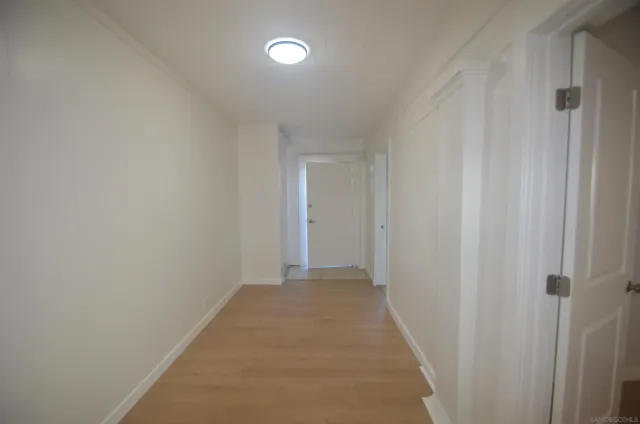 a view of a hallway with wooden floor