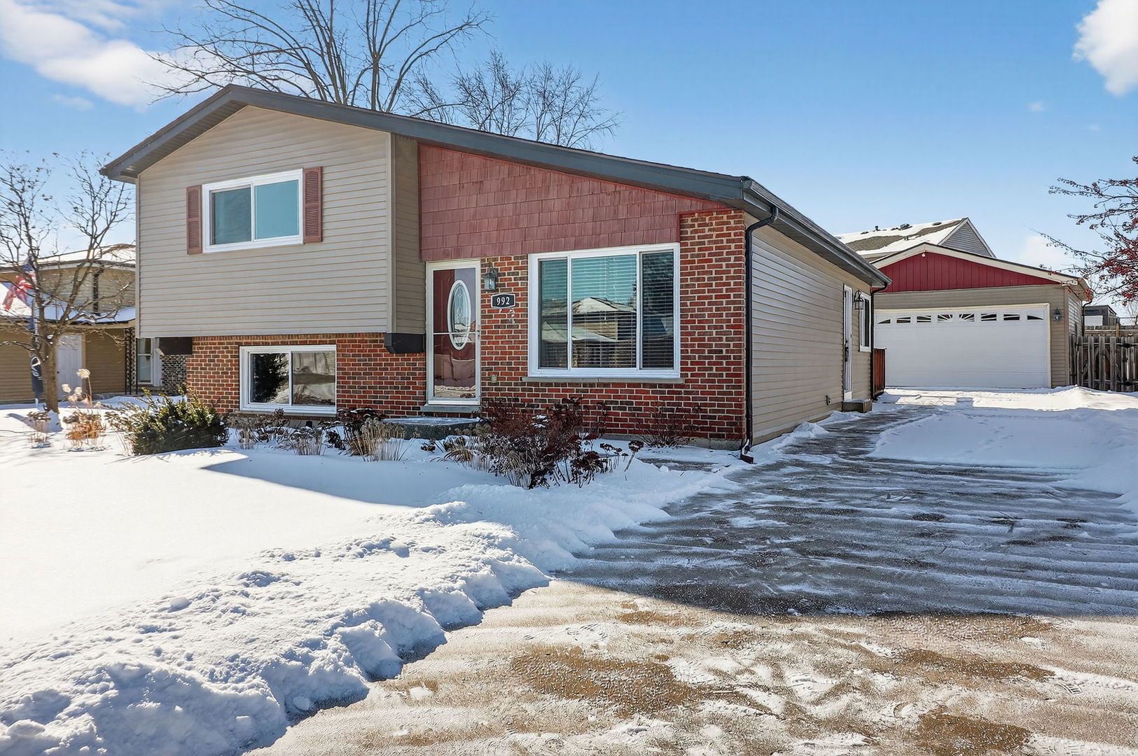 992 Navajo Street Carol Stream, IL 60188 - Photo 3 of 28 a front view of a house with a yard covered in snow