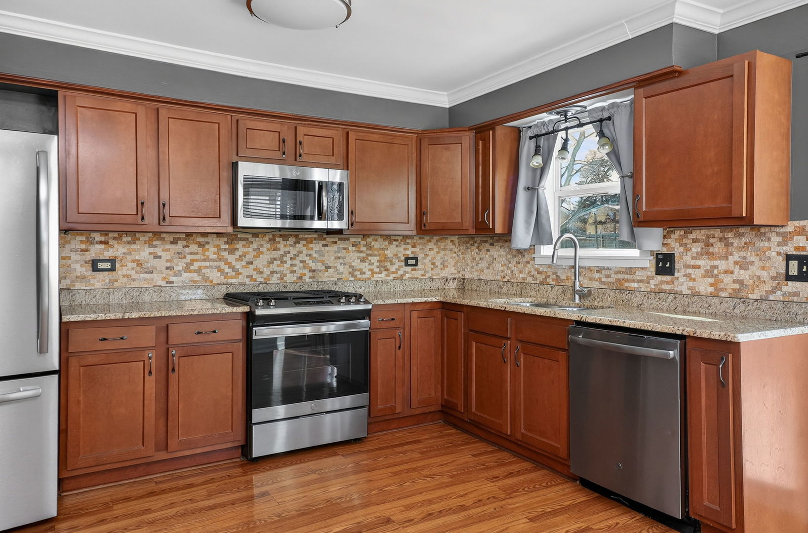 992 Navajo Street Carol Stream, IL 60188 - Photo 6 of 28 a kitchen with stainless steel appliances granite countertop wooden cabinets a stove a sink and dishwasher with wooden floor