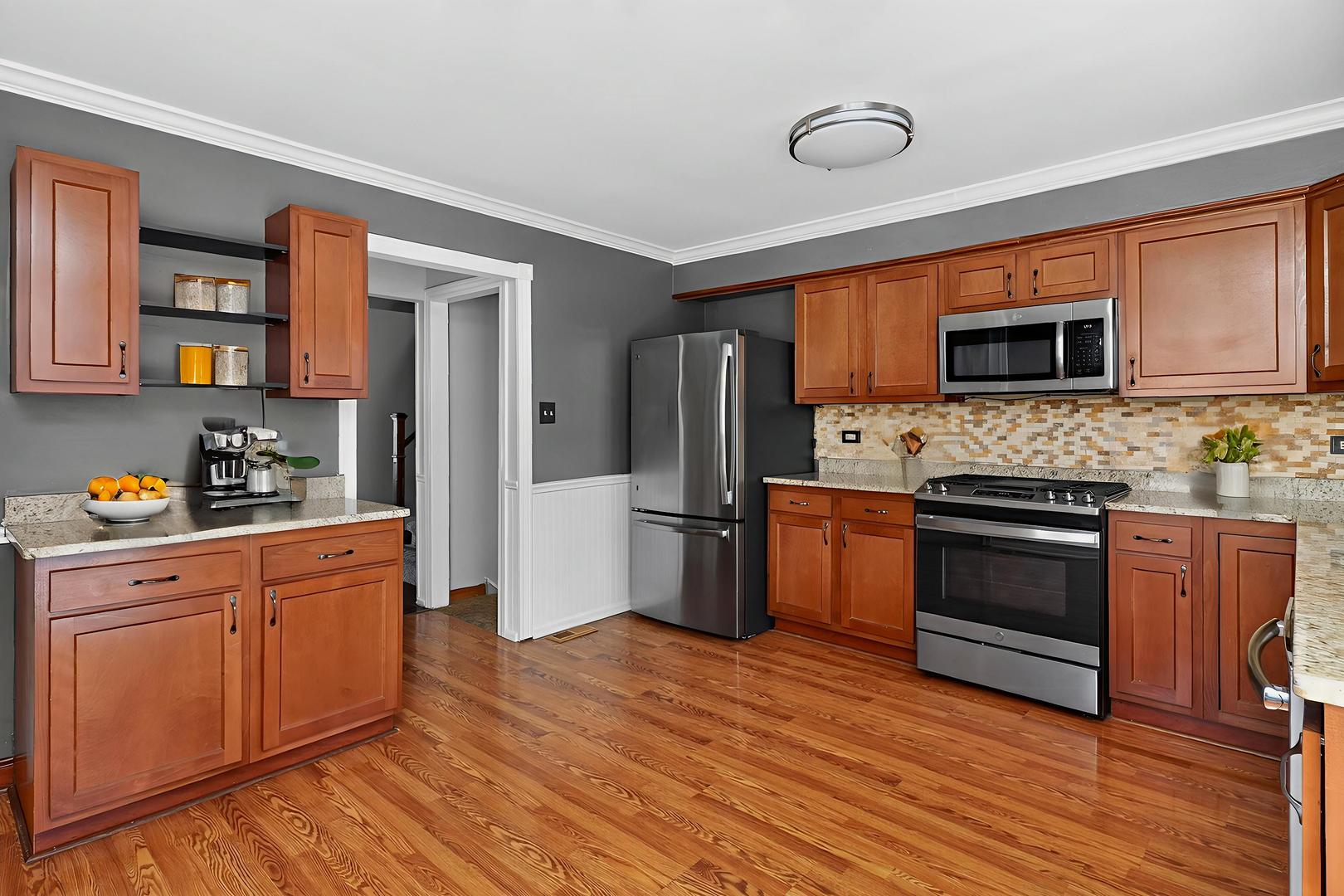 992 Navajo Street Carol Stream, IL 60188 - Photo 7 of 28 a kitchen with stainless steel appliances granite countertop a stove top oven a refrigerator and a microwave oven