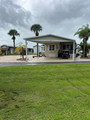 a view of a house with a big yard and sitting area