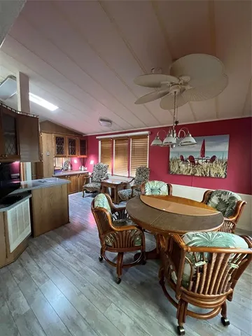 a living room with furniture a flat screen tv and kitchen view