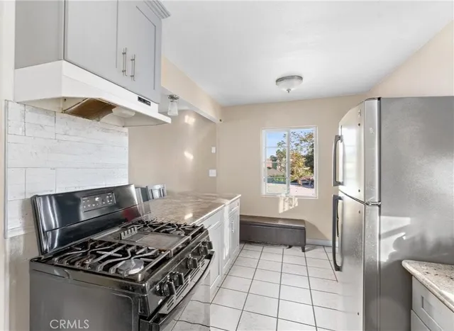 a kitchen with granite countertop a stove and a refrigerator