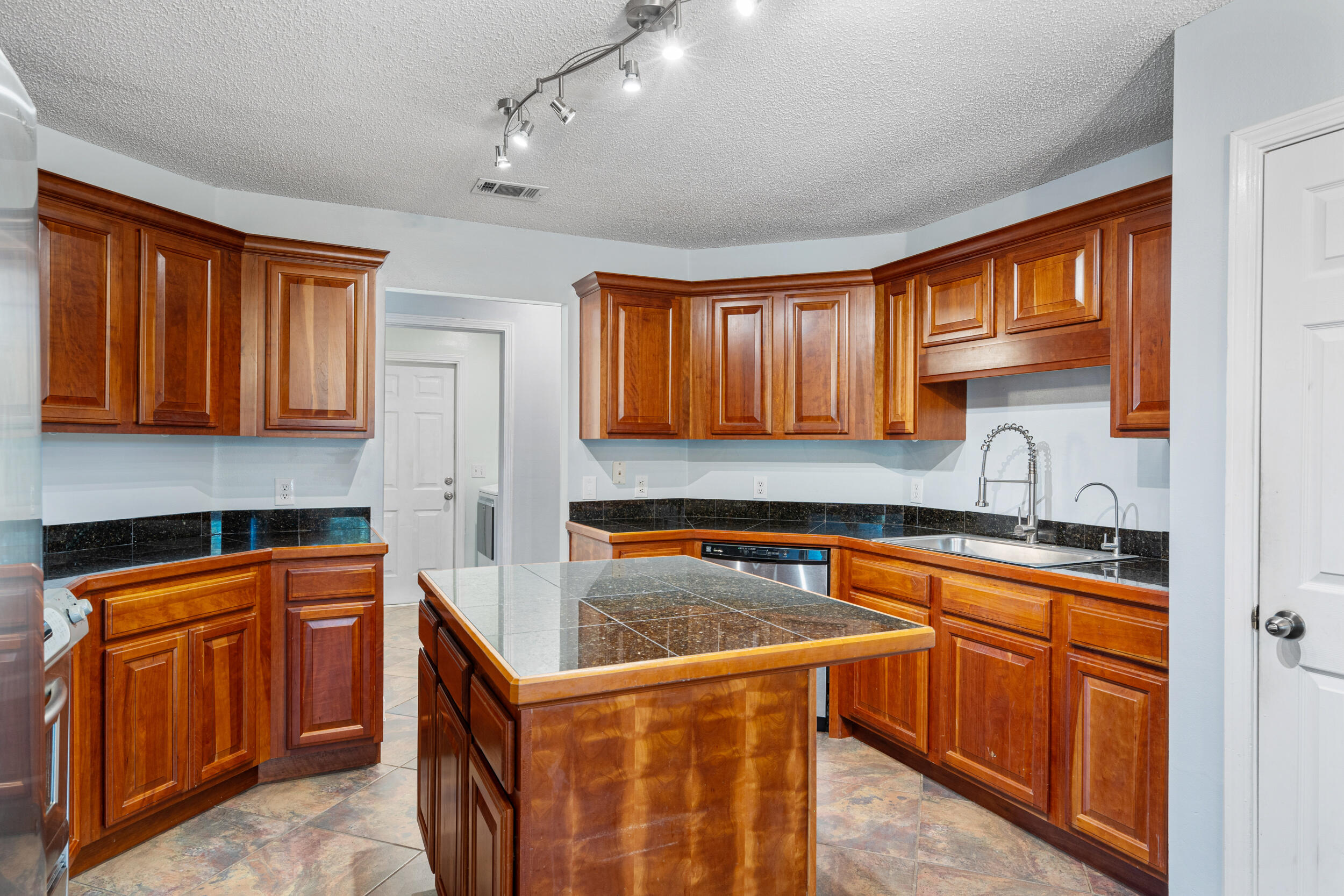 7933 Skyview Boulevard Navarre, FL 32566 - Photo 12 of 38 a kitchen with granite countertop a sink stove and cabinets