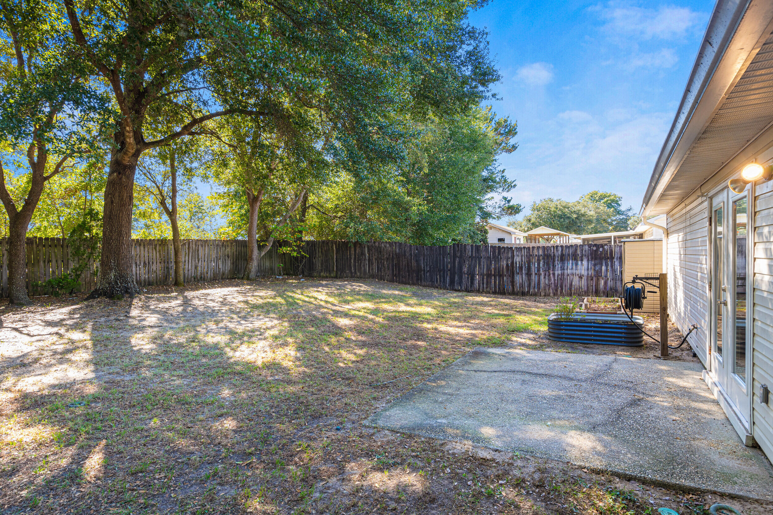 7933 Skyview Boulevard Navarre, FL 32566 - Photo 28 of 38 a view of a backyard with a large tree