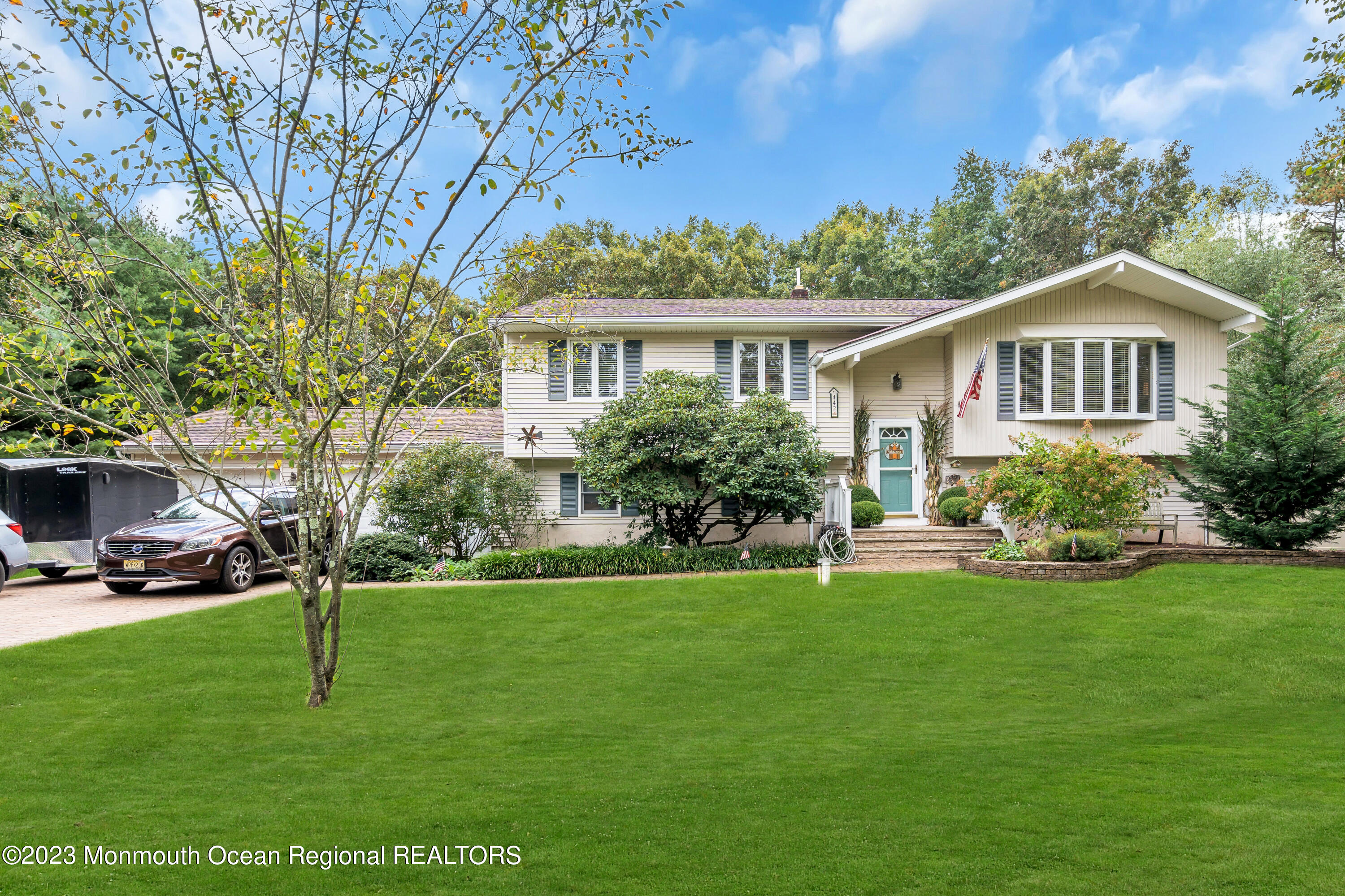 a front view of a house with a yard and trees