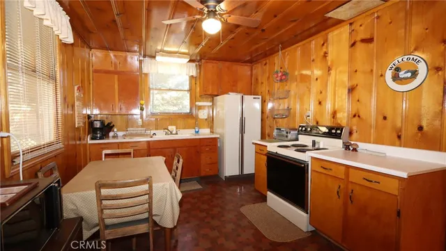 a room with stainless steel appliances kitchen island granite countertop a sink and cabinets