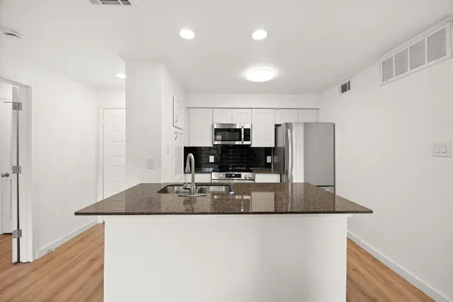 a kitchen with granite countertop a stove and a sink