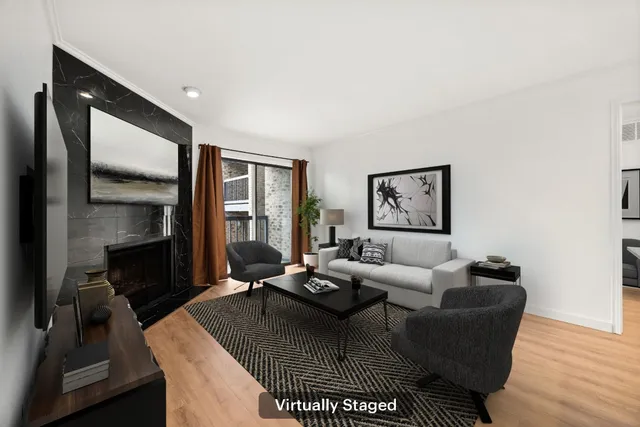 a view of an empty room with wooden floor and a fireplace