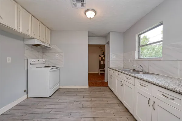 a kitchen with granite countertop white cabinets and white appliances