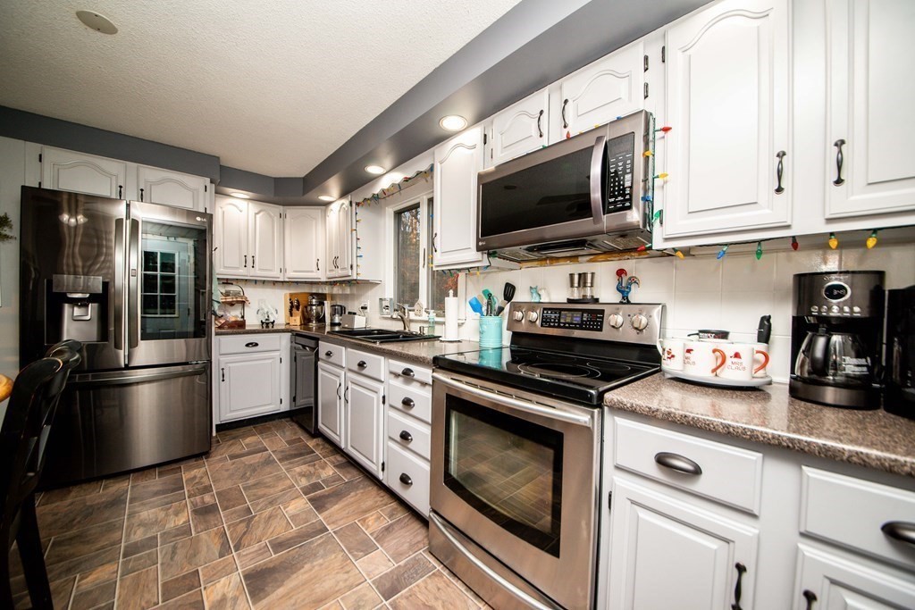16 Gammons Road Acushnet, MA 02743 - Photo 23 of 31 a kitchen with stainless steel appliances granite countertop a stove a refrigerator and a microwave