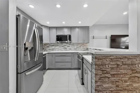a kitchen with stainless steel appliances white cabinets and a refrigerator