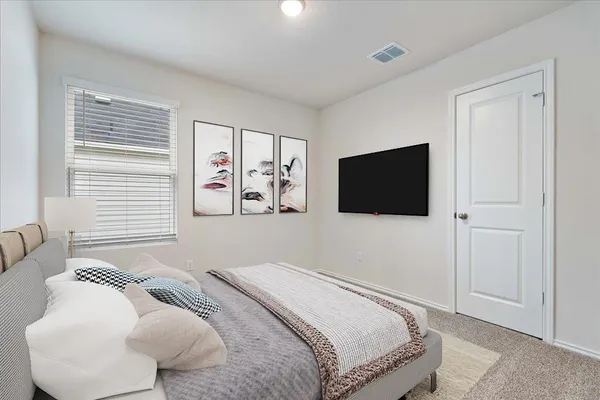 a bedroom with a flat screen tv and a bed