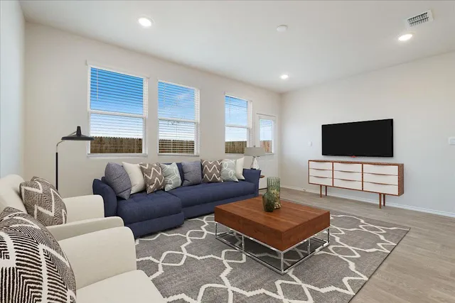 a living room with furniture and kitchen view