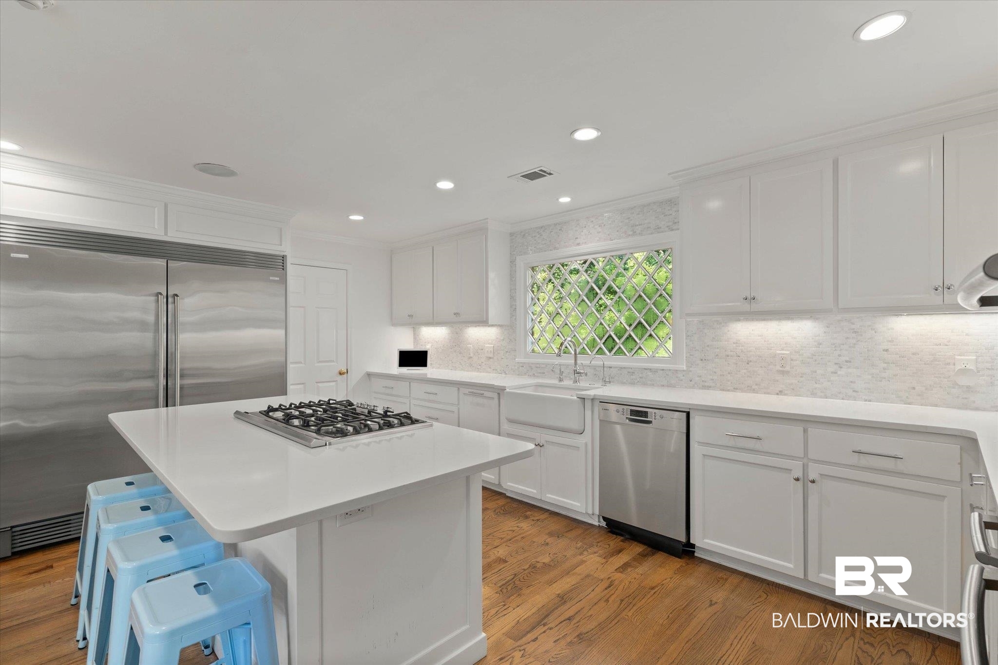 3612 Linden Lane Mobile, AL 36608 - Photo 13 of 42 Kitchen with appliances with stainless steel finishes, white cabinets, wood finished floors, light countertops, and ornamental molding