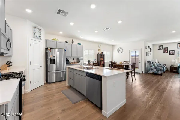 a large kitchen with stainless steel appliances lots of counter space and wooden floor