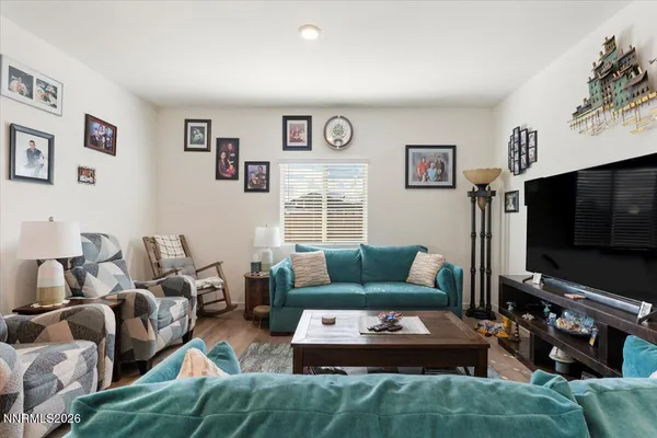 a living room with furniture a flat screen tv and a window