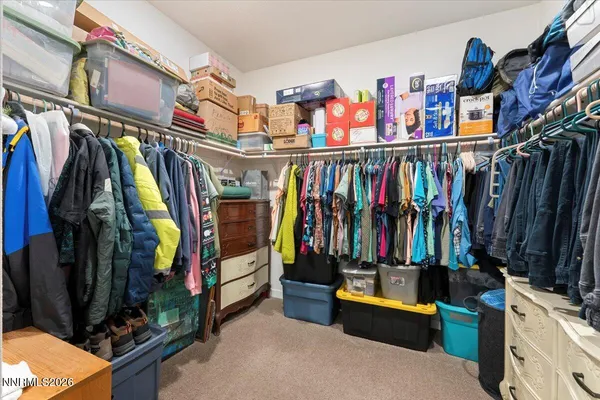 a view of walk in closet with clothes and shoes