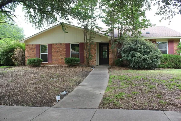 a front view of house with yard and trees around