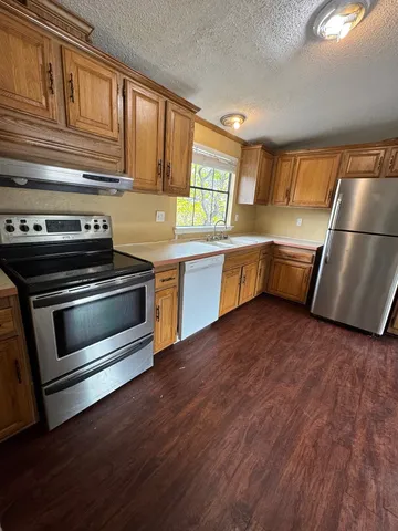 a kitchen with wooden floors and appliances